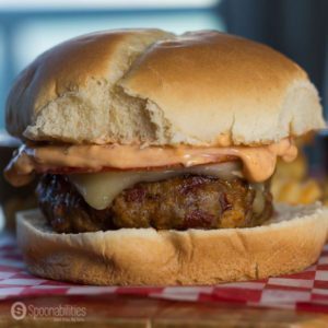 Close up of a Spicy Burger with Pesto Rosso, pepper jack cheese and spicy mayo