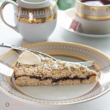 Slice of Fig Almond Cake on a gold-rimmed cake plate and fork