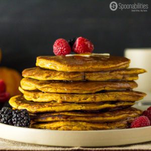 side view of eight Spiced Pumpkin Pancakes topped with Vermont Maple Syrup