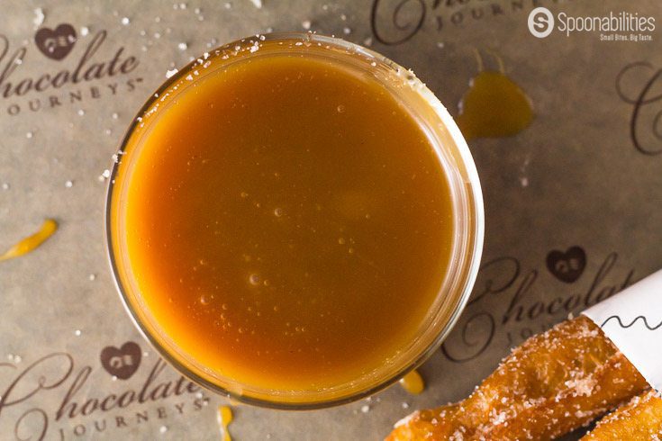Traditional Spanish churros dipped in Salted Caramel Sauce from Coop's is the perfect crispy & sugary snack. Spoonabilities.com