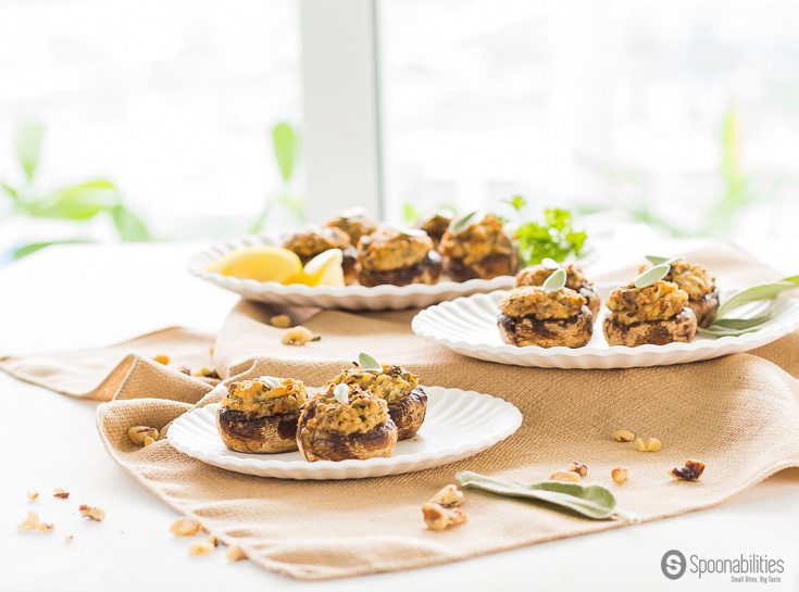 Three plates of many Artichoke Pesto Stuffed Mushrooms