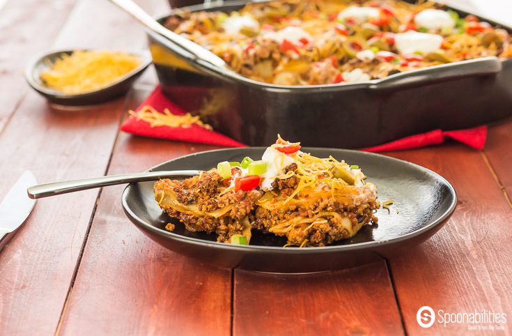 Plate of Mexican Lasagna with full lasagna in background