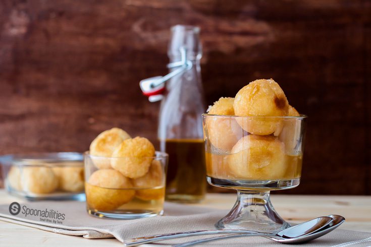 Fried dough balls soaked in syrup, Dominican Buñuelos is a traditional dessert recipe made during Easter. Read my Immigrant Food Stories, along with the recipe at Spoonabilities.com