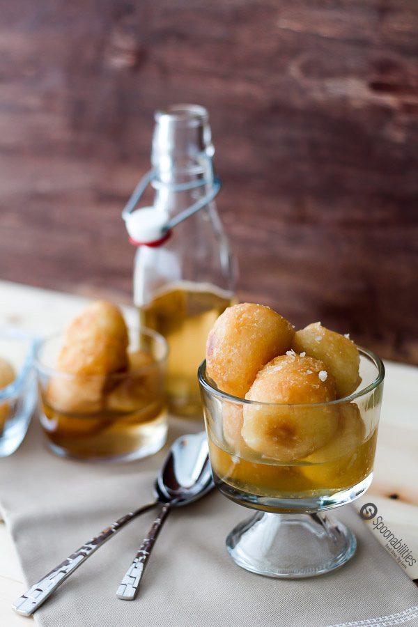 Dominican Buñuelos are fried dough balls soaked in syrup. Traditional dessert served during Easter week. Bunuelos are made from yuca or potatoes. Read my Immigrant Food Story at Spoonabilities.com