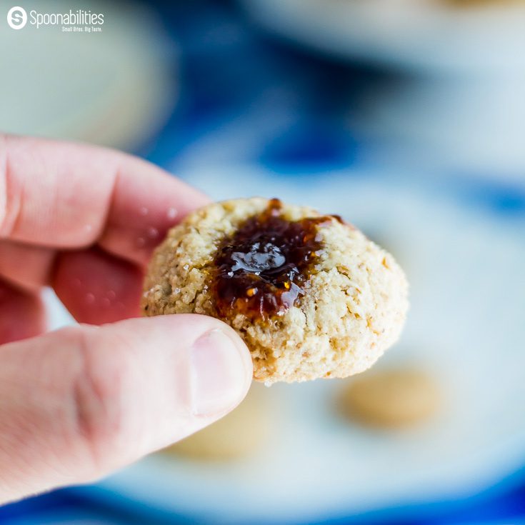 Super closeup of one Walnut Macaroon Thumbprint Cookie with fig jam in the center