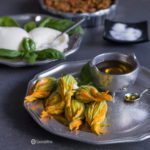Fresh Stuffed Squash Blossoms is a unique appetizer, filled with creamy burrata and Kalamata olive and oregano spread. Delicious light and easy recipe. Spoonabilities.com