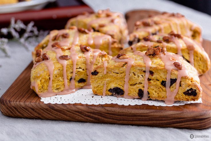 Fall-inspired Pumpkin Scones with sweet & tart dried cherries. Delicious breakfast or tea cake drizzled with blood orange and maple syrup glaze, and a sprinkle of roasted pumpkin seeds. Spoonabilities.com