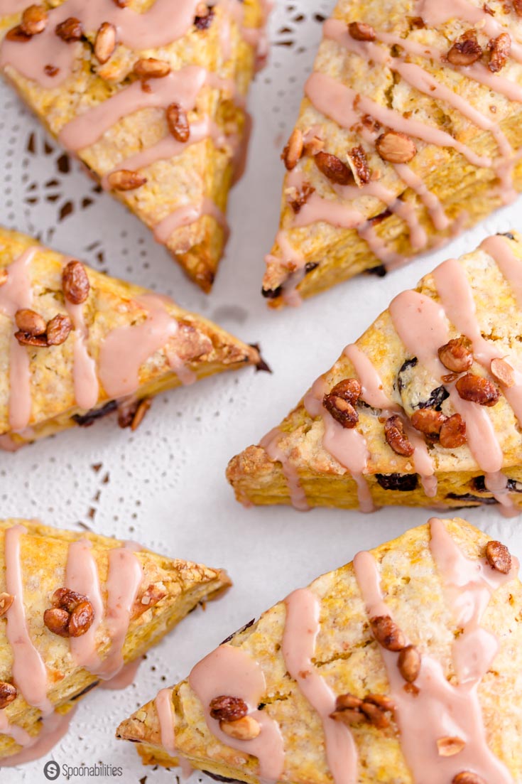 Closeup shot of six Cherry Pumpkin Scones topped with toasted pumpkin seeds. Spoonabilities.com