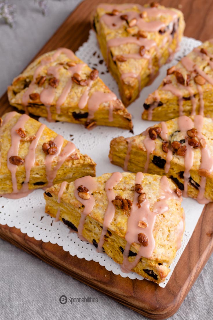 Closeup shot of six Cherry Pumpkin Scones on a wood cheese board