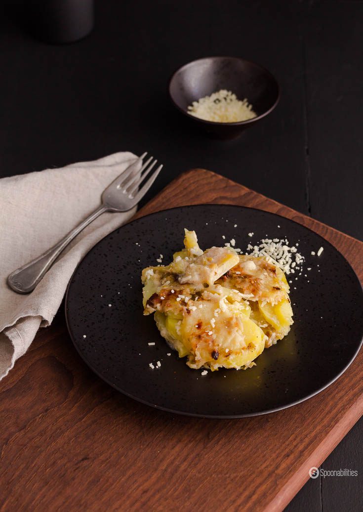 Potato gratin with leek on a brown plate.