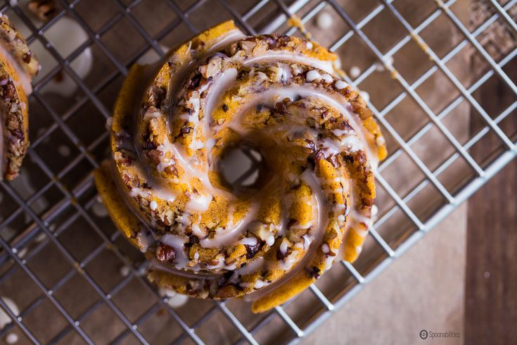 Mini Pumpkin Pecan Cakes is a combination of doughnuts and cake, all in one piece of heaven with orange glaze. Spoonabilities.com