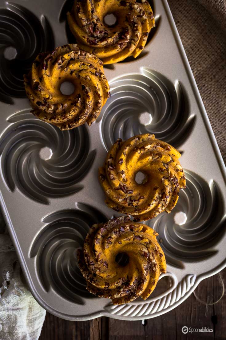 Pumpkin Pecan Cakes is like eating spongy doughnuts with crunchy pecan bites and a wonderfully sweet orange glaze. Spoonabilities.com