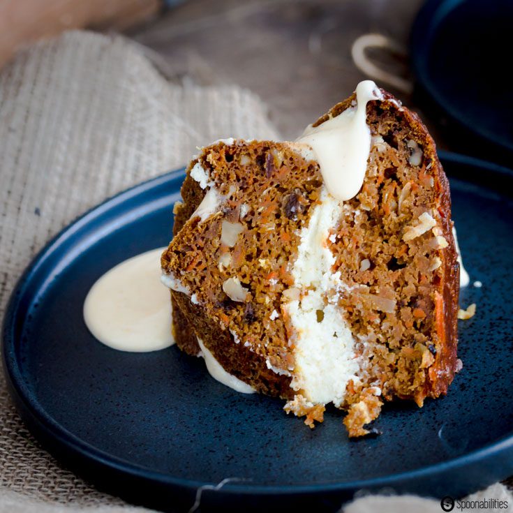 close up shot of piece of Pumpkin Carrot Bundt Cake with a delicious cheesecake layer and a cream cheese syrup glaze