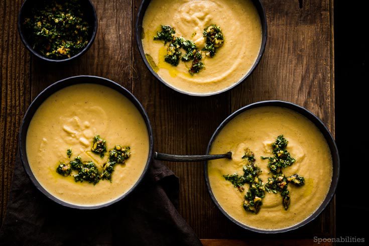 Three Black bowls with creamy Celery Root Soup topped with Walnut-parsley gremolata. Spoonabilities.com