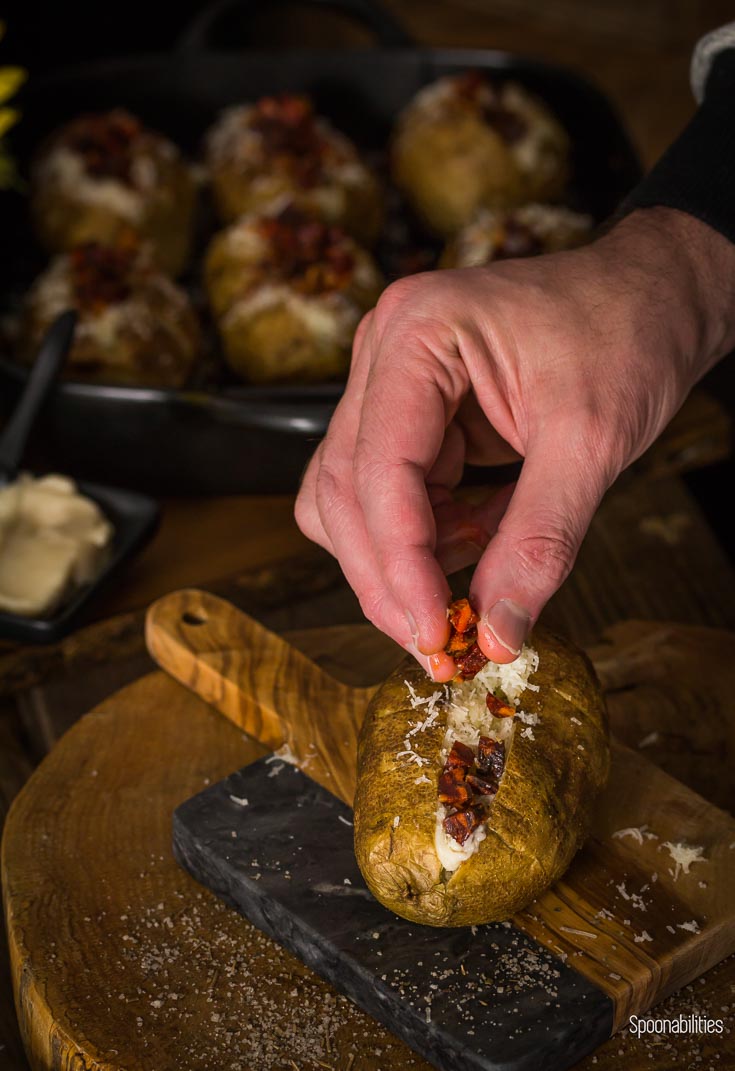 Topping a baked potato with Ibérico chorizo, after layering on other Spanish inspired toppings like aioli and manchego cheese. Spoonabilities.com