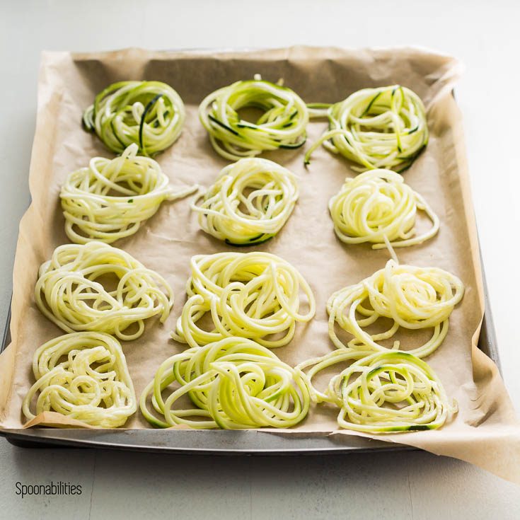 Baking tray with 12 bird nest Zucchini noodles.This recipe inspired by Mediterranean flavors of lemon artichoke pesto. Spoonabilities.com