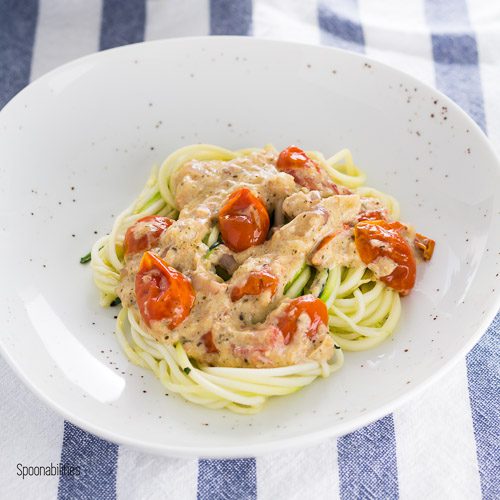 A plate with a Mediterranean flavor inspired Zucchini Noodles (zoodles) with artichoke lemon pesto & roasted cherry tomatoes. A healthy recipe is full of flavor; quick and easy to make in under 30 minutes. Spoonabilities.com
