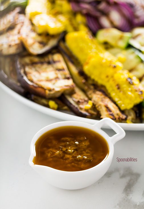 Black olive tapenade vinaigrette in a small white bowl and the Grilled Summer Vegetables in the back. Spoonabilities.com