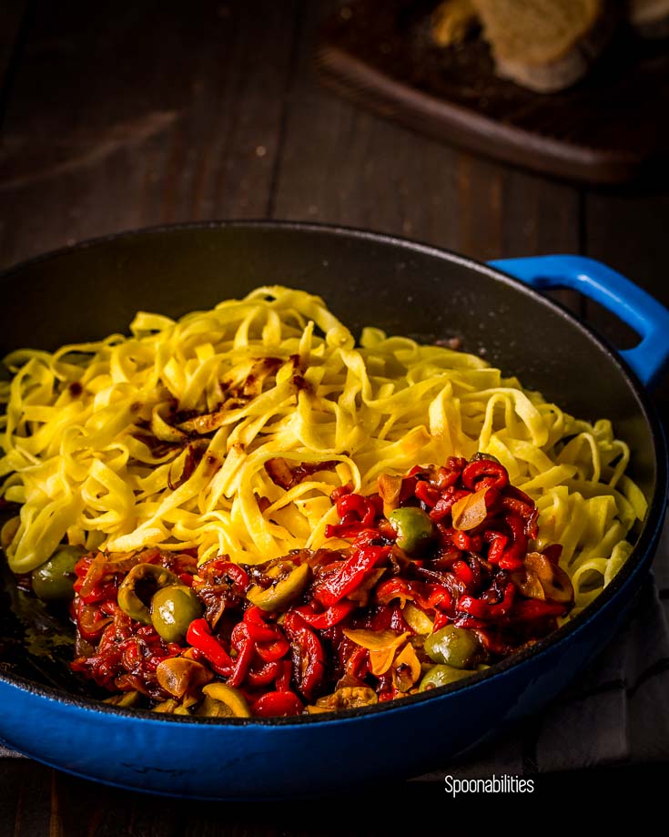 Blue cast iron skillet with roasted red pepper & Sicilian olives with Egg Tagliatelle pasta. Spoonabilities.com