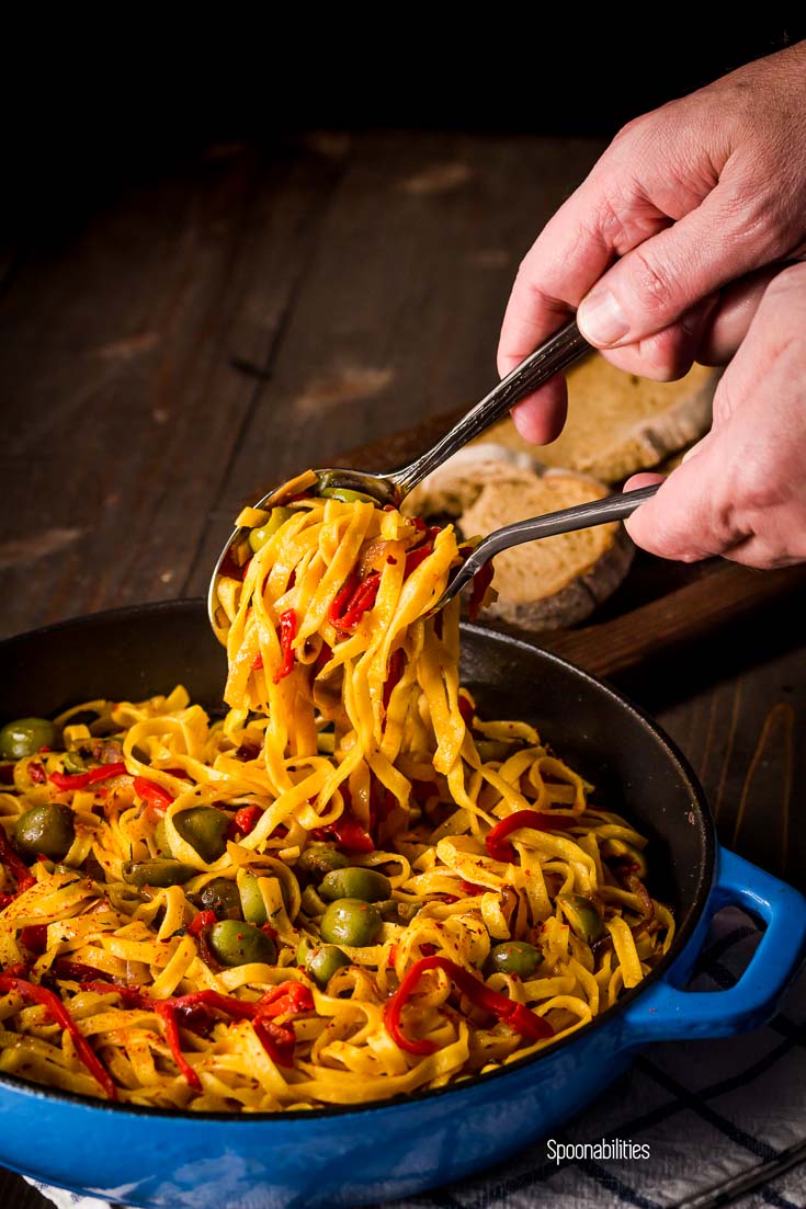 Serving the Roasted Red Pepper Pasta with Sicilian Olives in blue cast iron skillet. Spoonabilities.com