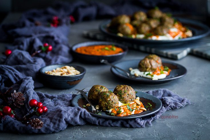 Landscape photo with two small plate and one large plate with Greek yogurt, spiced lamb meatballs and piquillo pepper pesto. Spoonabilities.com