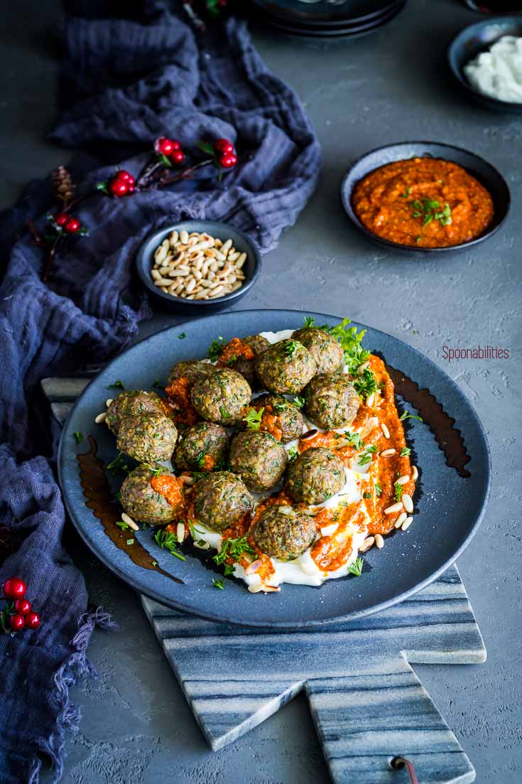 Large plate with Spiced lamb meatballs can be made in 15 minutes, and ahead a time. Mediterranean flavors from fresh herbs and spices give an amazing flavor. This lamb meatball recipe is perfect as an appetizer or a main dish. Serve in a bed of Greek yogurt and a Piquillo pepper pesto. Spoonabilities.com
