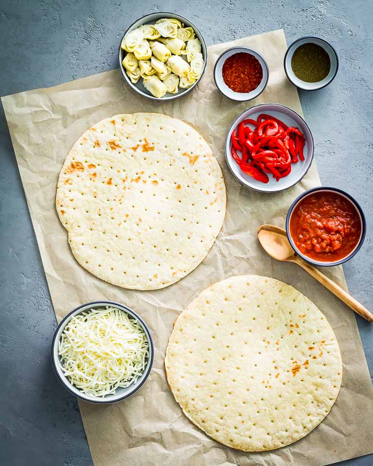 Ingredients for the Cauliflower Crust Pizza in a small bowls with pizza sauce, baby artichokes, mozzarella, roasted red pepper, Dominican Oregano & Aleppo Pepper. Spoonabilities.com