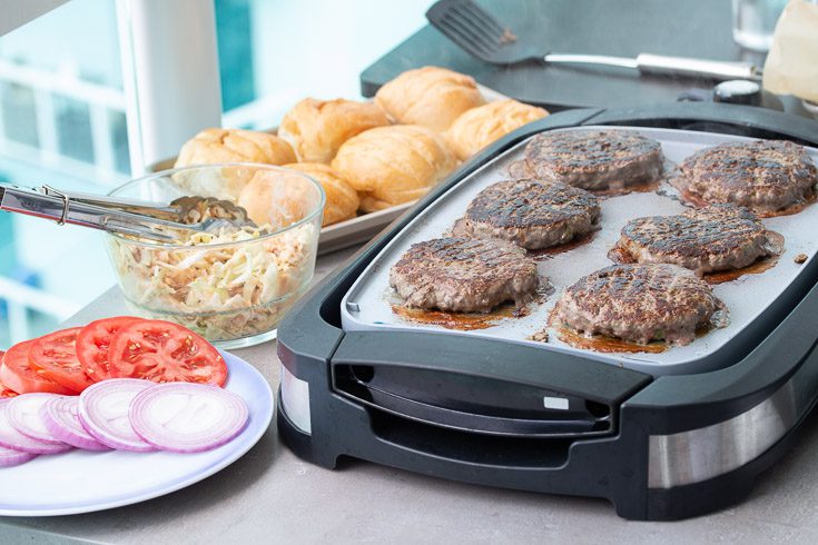 Grilling six burger patties on the Oster electric grill. Spoonabilities.com