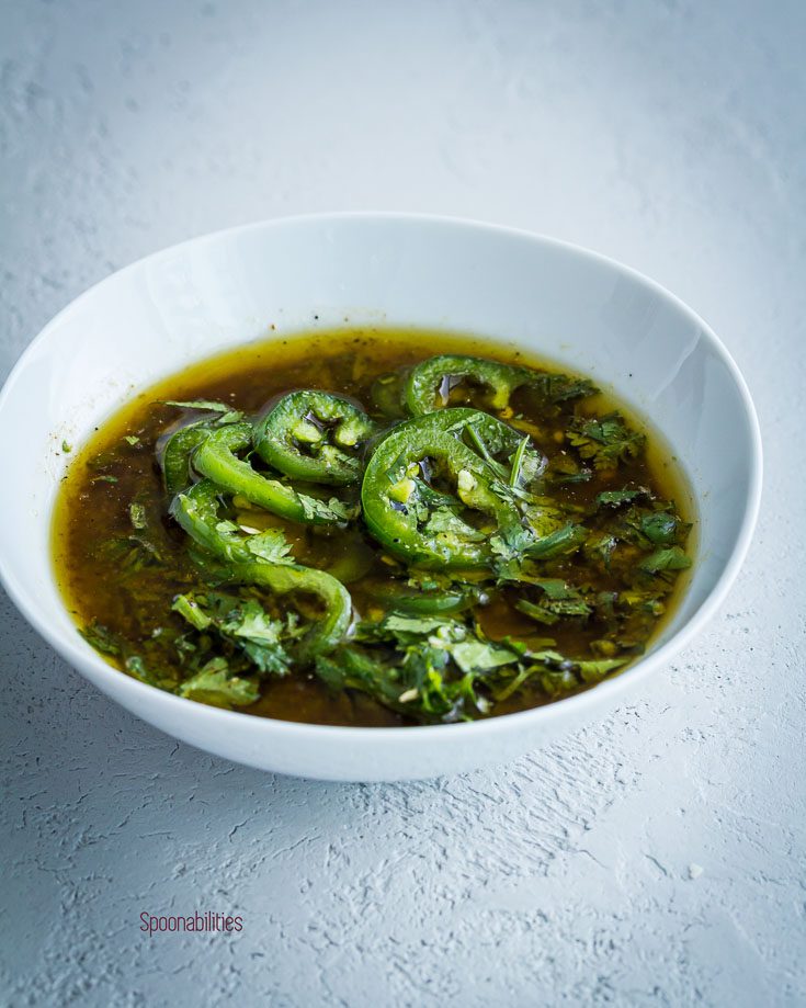 Jalapeño lime Marinade with extra virgin olive oil, cilantro and garlic in a small bowl. Spoonabilities.com