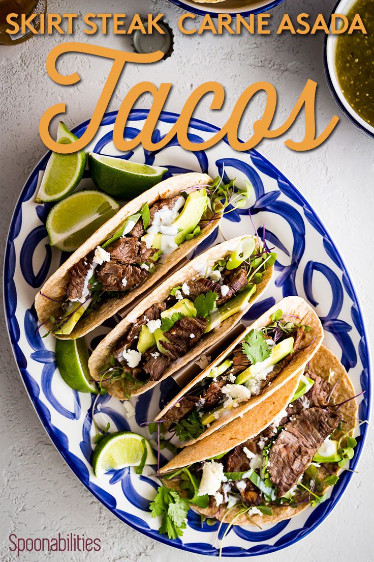 Blue and white oval plate of four Skirt Steak Tacos - Carne Asada Tacos with lime wedges Spoonabilities