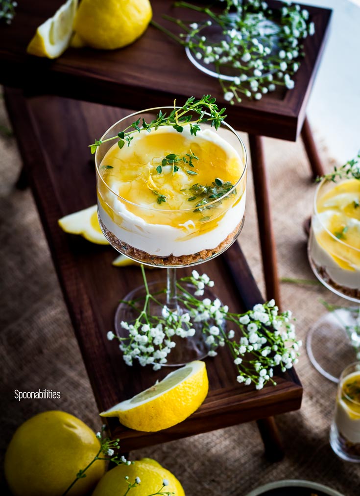 No-Bake Cheesecake in a cocktail glass garnished with a thyme lemon herb. Spoonabilities.com