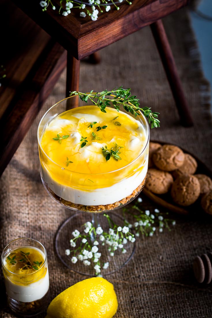 No Bake Cheesecake served in a cocktail glass with an amaretti cookies crust and Honey-Thyme Drizzle. Spoonabilities