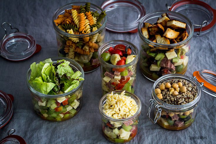 Six open jars with salad and different variation for a meal plan. Spoonabilities.com