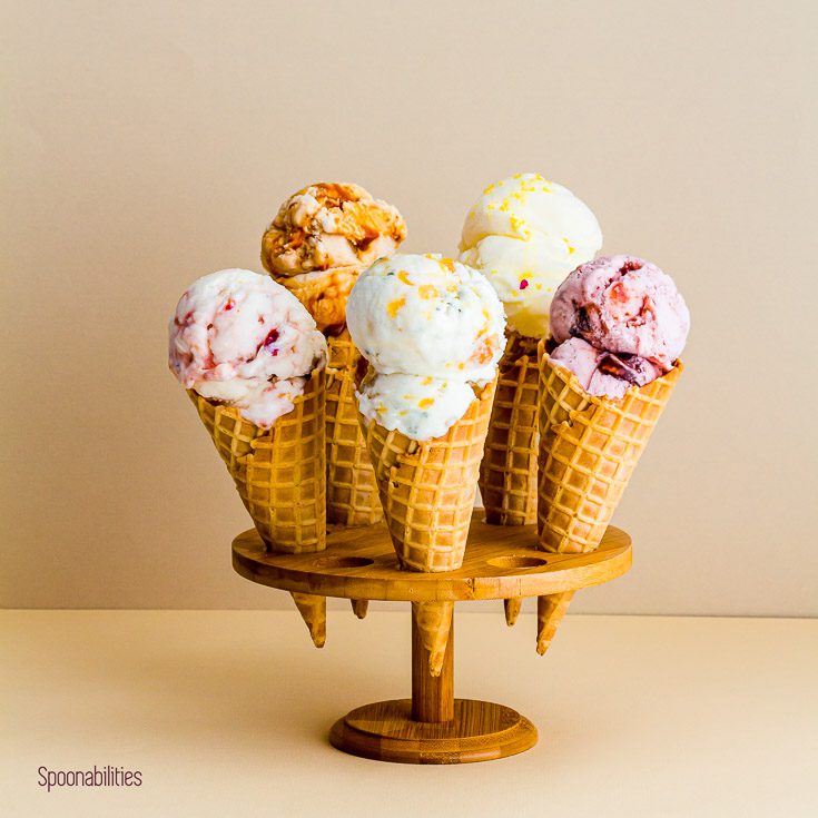 Five ice cream flavors in a waffle cone on a stand, made from homemade eggless ice cream base. Spoonabilities.com