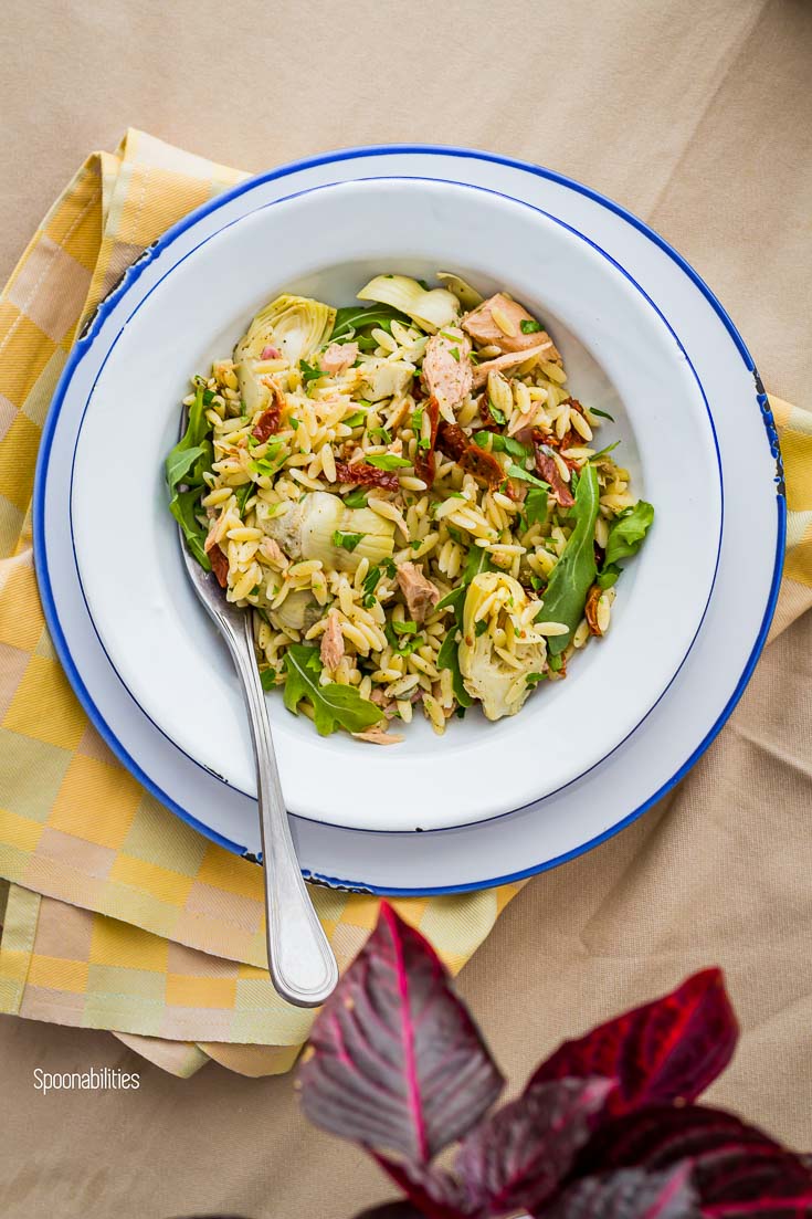 Enamelware pasta plate with Orzo Tuna pasta salad and a fork in the left side of the plate. Spoonabilities.com