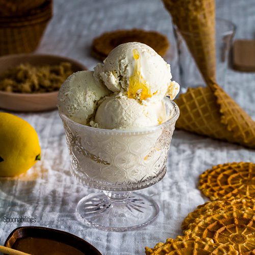 Three scoop of homemade labneh ice cream in a glass cup with a drizzle of Leatherwood Honey with waffle cones in the background. Spoonabilities.com