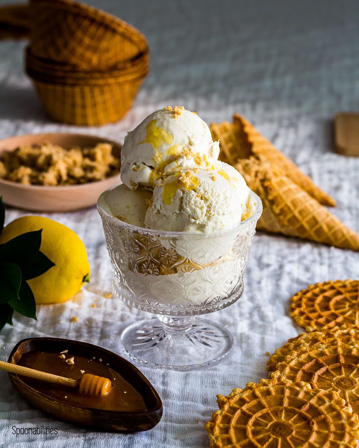 homemade ice cream topped with sesame halva an honey in a glass cup with waffle cones in the background. Spoonabilities.com