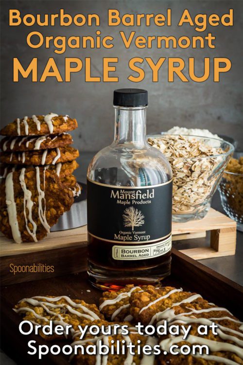 Bottle of Organic Bourbon barrel aged Vermont Maple Syrup surrounded by Oatmeal Raisin Cookies