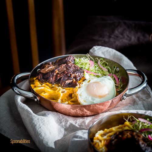 mouthwatering braised Short Ribs served in a personal saucepan. Garnished with crispy friend egg, Alfalfa Sprouts and pickled red onions. Spoonabilities.com