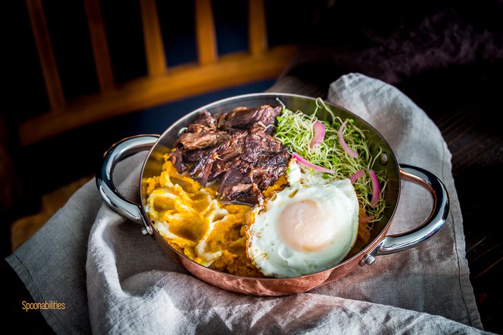 Close up photo with brandy braised short ribs with mashed pumpkin with a crispy fried egg. Spoonabilities.com