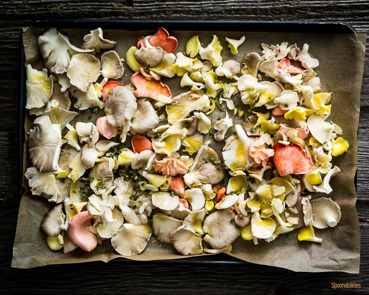 Baking tray with mixed oyster mushroom seasoned with olive oil, garlic & thyme. Spoonabilities.com