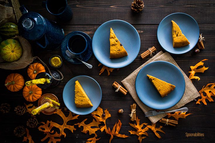 Four small blue plate and each of them with Pumpkin Cornmeal Coconut Cake. The background with fall decor. Spoonabilities.com
