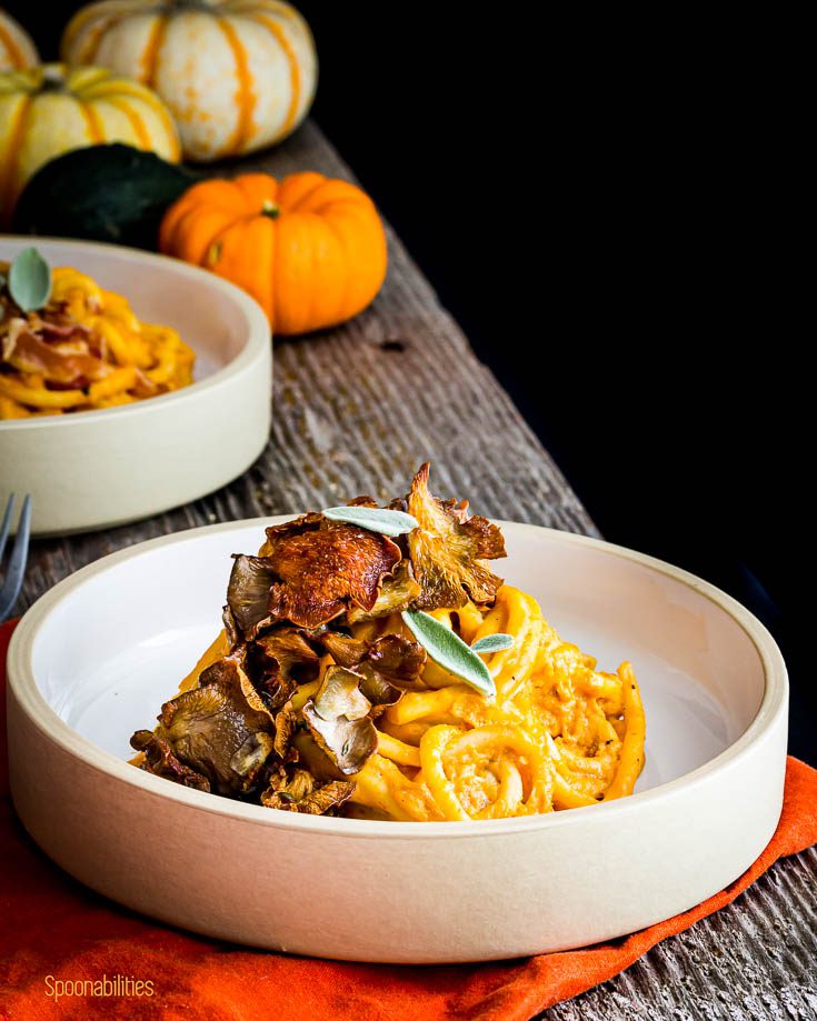 Pasta bowl with pici pasta tossed with pumpkin pasta sauce and topped with crispy oyster mushrooms. Spoonabilities.com
