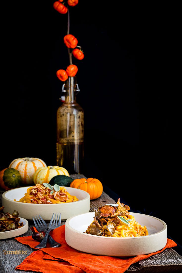 Table set up with two pasta bowl and decorated with pumpkin and Fall decor. Spoonabilities.com