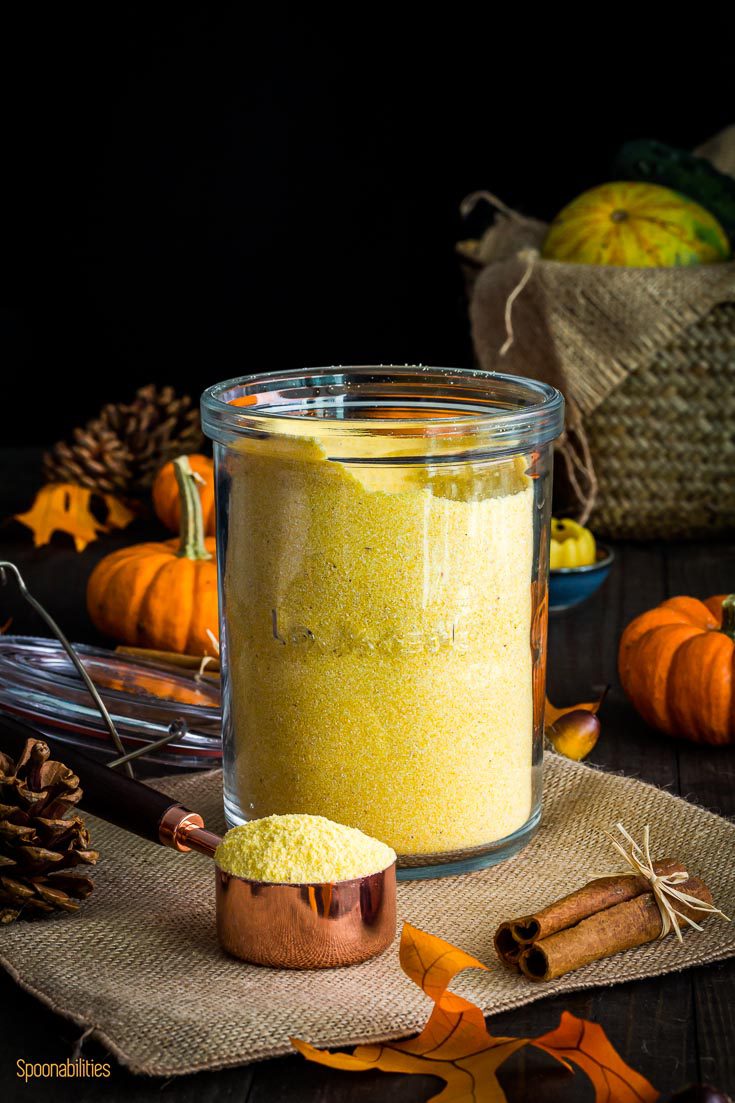 Cornmeal in a glass jar with a measuring cup with some of the cornmeal. Spoonabilities.com