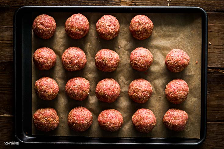 16 raw meatballs in the baking try before go to the oven. Spoonabilities.com