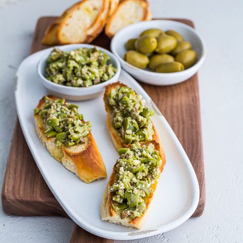 Three servings of Greek Olive Crostini on a white plate
