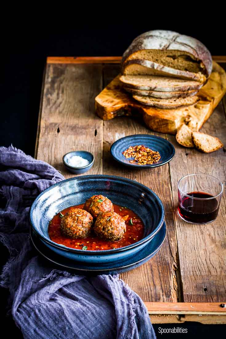 Pasta blue bowl in a wooden table with three Jumbo Brisket Meatballs in San Marzano Tomato Sauce. Spoonabilities.com