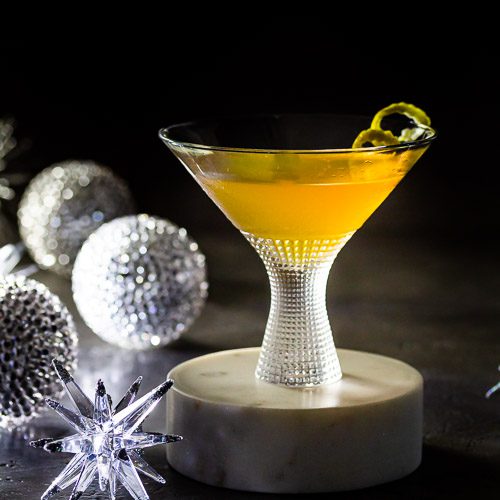 close up of Leap Year Cocktail in a short martini glass on a marble pedestal.