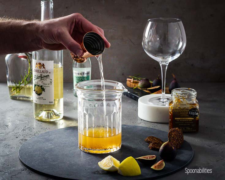 Pouring shot of rosemary gin making a Bloomsbury Garden Cocktail